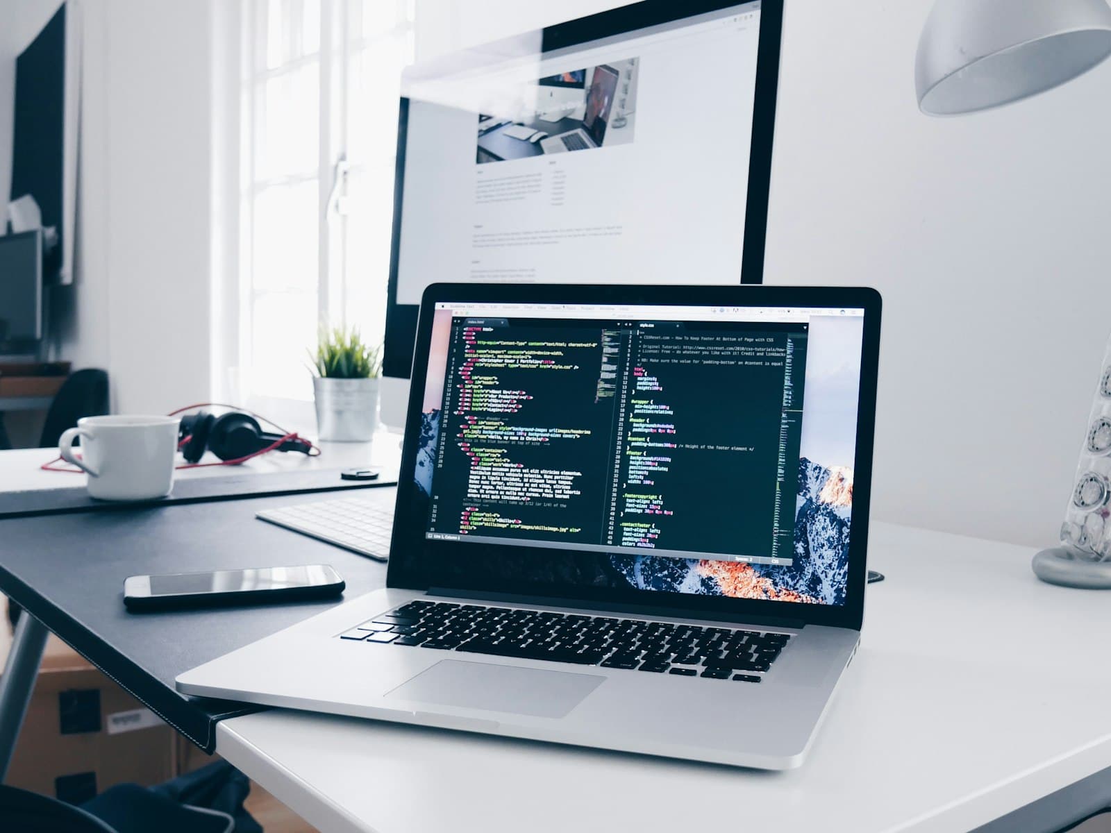 Laptop on a desk with application code on screen